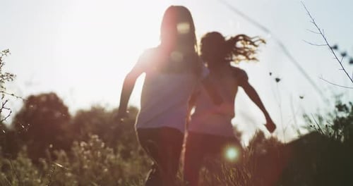 Two children running through grass