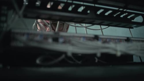 Man Working with Wires on a Computer Server