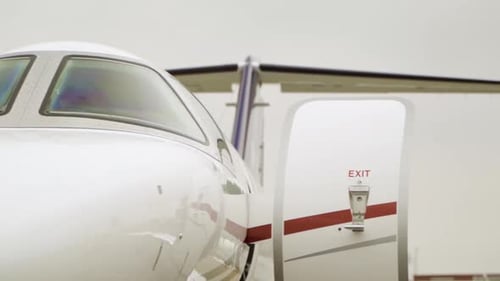 Plan panoramique d'un avion de luxe Cessna dont les portes de stationnement sont ouvertes à l'aéroport par temps nuageux. Angle bas