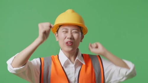 Close Up Of Female Engineer With Safety Helmet Dancing And Celebrating In The Green Screen