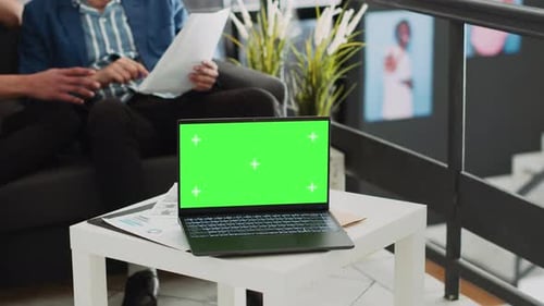 Laptop with Green Screen in Modern Office Setting