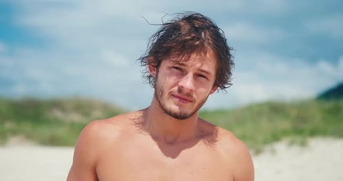 Young man's portrait. Portrait of the young Brazilian surfer on the beach. Hand held camera
