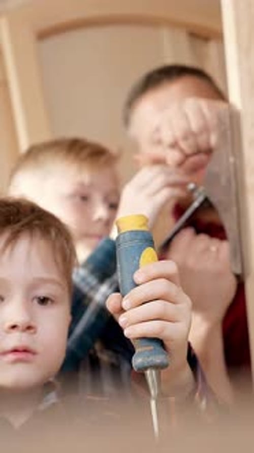 Father and Sons Building a Wooden Structure Together