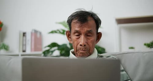 Senior man using laptop computer at home