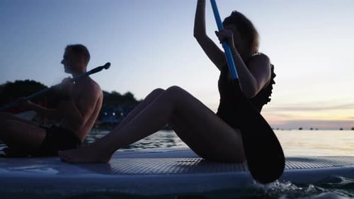 Couple Paddling Their Paddle Surfboards and Smiling in Thailand
