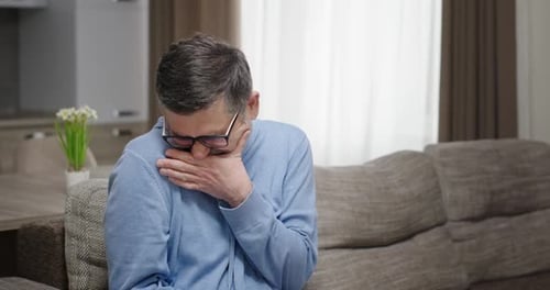 Un anciano de pelo gris con barba y bigote se avergüenza, se comporta de forma antinatural y muy emocional