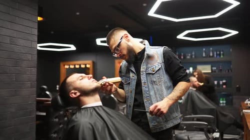 Barber Shaves Man's Facial Hair in Shop