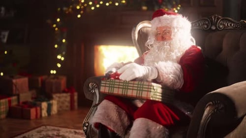 Santa Claus Unwrapping Gift by Cozy Fireplace