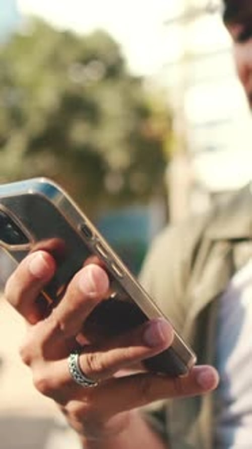 Close-up of young man's hands using phone