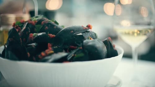 Steaming Mussels in Bowl Next to Wine