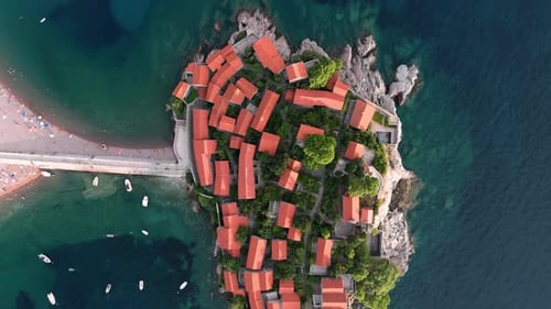 Rotating upwards birdview on the Sveti Stafan with their houses of the luxury resort revealing the i