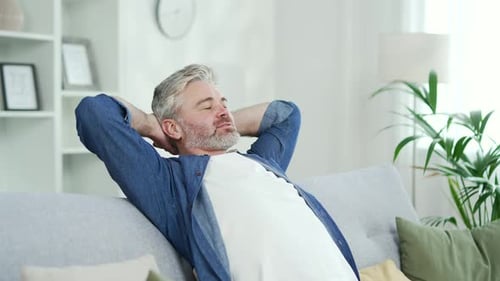 Man Relaxing on Couch in Bright Living Room
