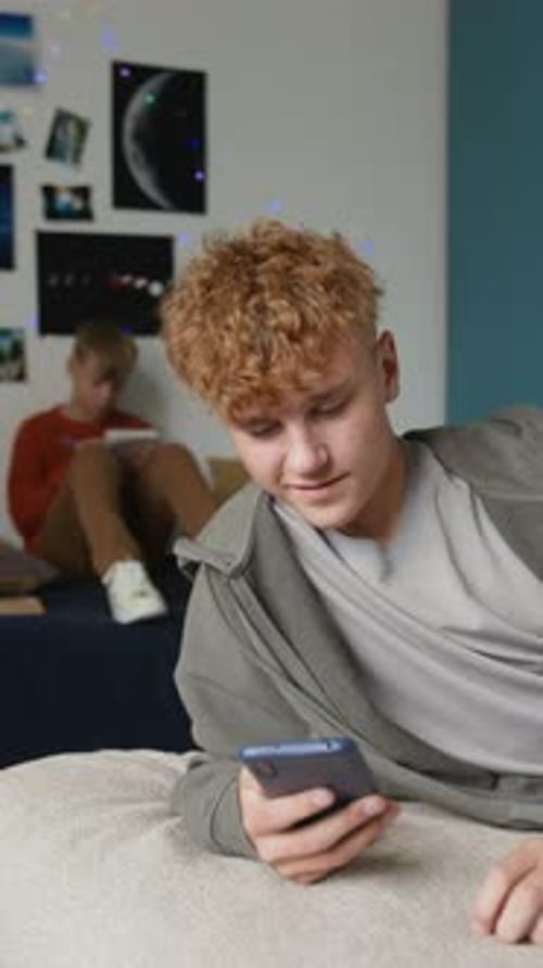 Teenager using phone while lying on bed