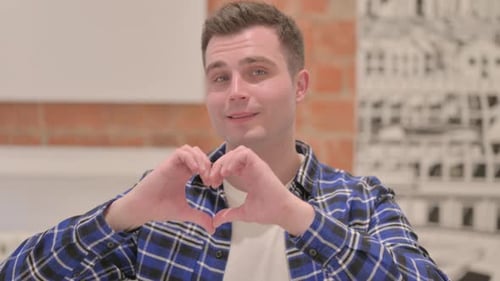 Young Man Makes Heart Shape with Hands