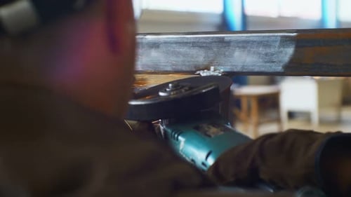 Man Grinds Connected By Welding Metal Carcass Closeup