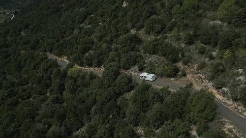 White motorhome travelling through mountain region south of france, aerial