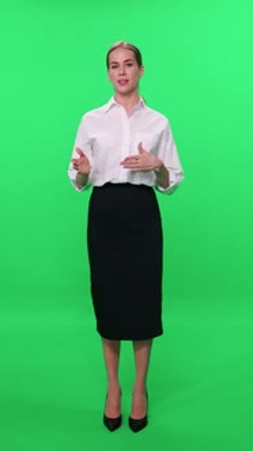 Woman Blogger in Suit Looks Into the Camera and Speaks on a Green Background Template for TV News
