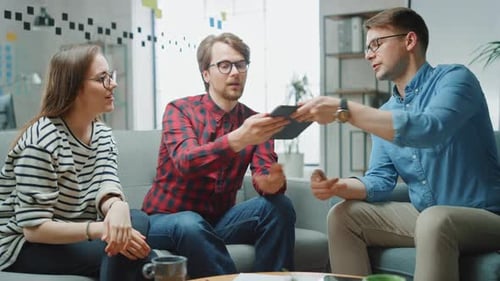 Coworkers Collaborate on Tablet in Modern Office