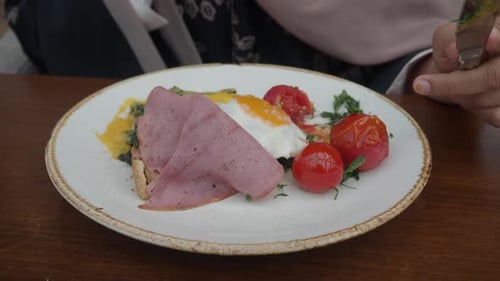 Woman Enjoys Elegant Brunch with Eggs and Ham