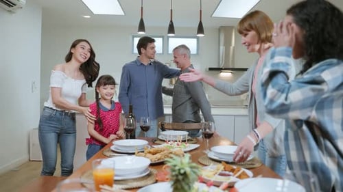 Multi-ethnic big family having dinner, enjoy evening party in house.