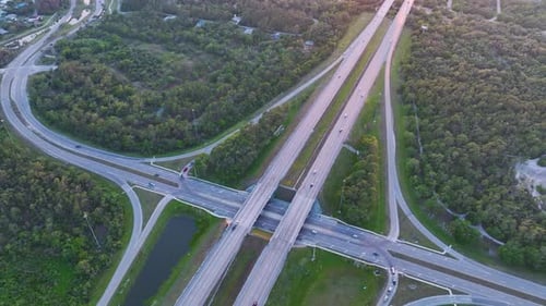 View From Above of Busy American Highway Crossroads with Fast Moving Traffic in Green Florida Area