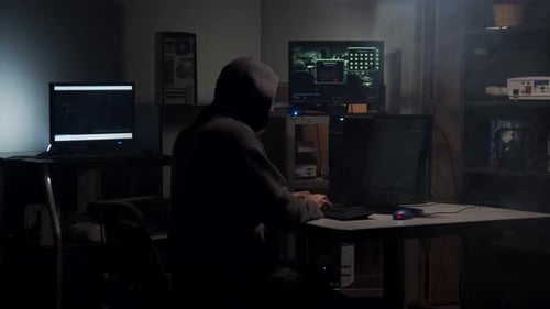 Hooded Hacker Coding in Dark Room