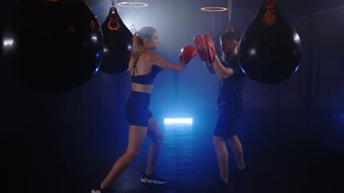 Caucasian Woman is Practicing Work Out of Shadow Boxing with Personal Trainer Coach in the Smoky