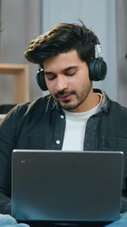 Man Talking on Headset at Laptop Indoors