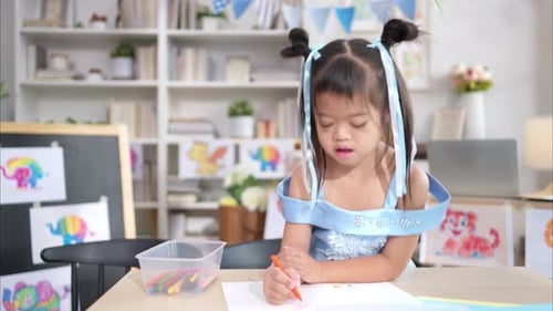 Girl Drawing with Crayon at Home