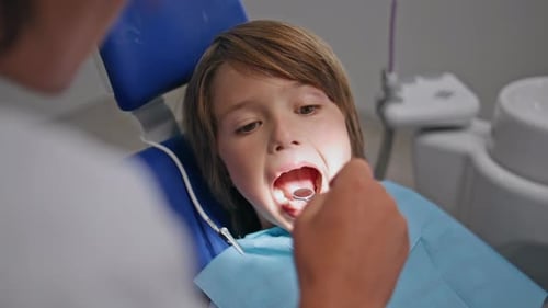 Pediatric Dentist Checking Teeth in Boy at Modern Stomatology Clinic Closeup