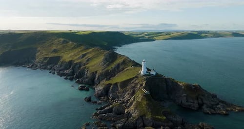 Light House Buildings At The End Of A Spectacular Rocky Coastline And Calm Waters Aerial Shot