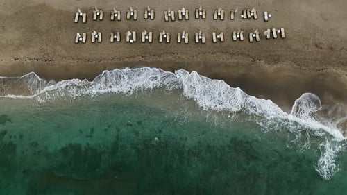 Aerial View of Beach with Waves and Chairs
