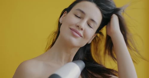 Woman Dries and Styles Long Dark Hair