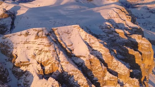 Warm Sunlight Highlights the Rugged, Snow-dusted Rock Faces on Sass Pordoi, With Piz Boè Rising