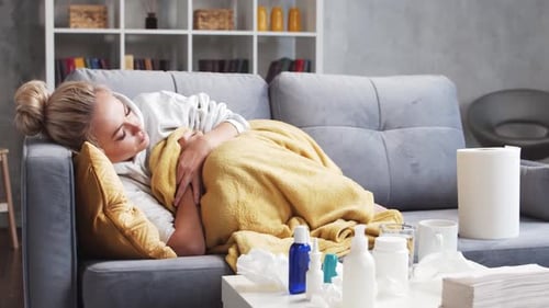 Jeune femme malade du rhume à la maison en auto-isolement La fille a de la toux, un nez qui coule et de la fièvre