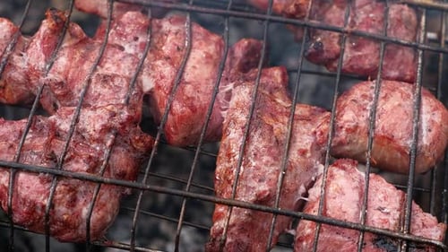 Schweinekopo in Scheiben geschnitten auf dem Grill Schaschlik Schweinestücke auf dem Rost Gegrilltes Fleisch mit geräuchertem Essen