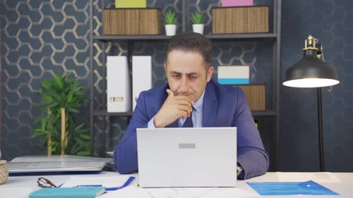 Man Typing and Thinking at Office Desk