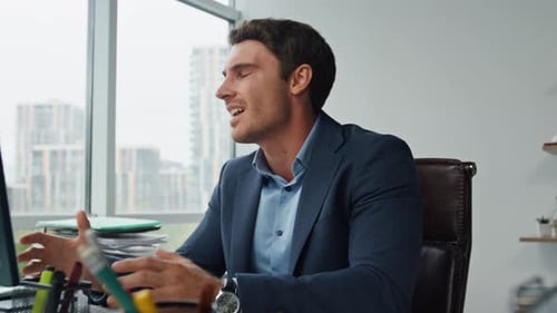 Corporate Man Talking at Desk in Bright Office
