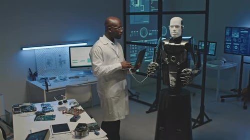 Robotics Engineer Setting Up Human Robot on Laptop