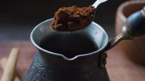 Pouring Ground Coffee Into Cezve with Teaspoon Close Up