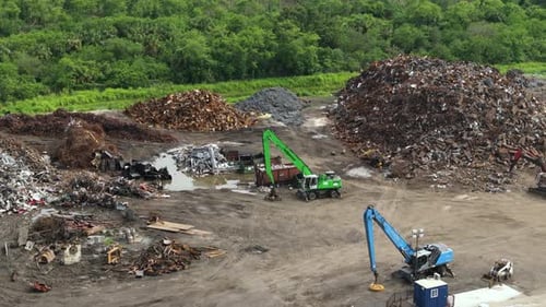 Steel Dump Junkyard with Cranes Recycling Old Scrap Metal Equipment at Industrial Scrapyard