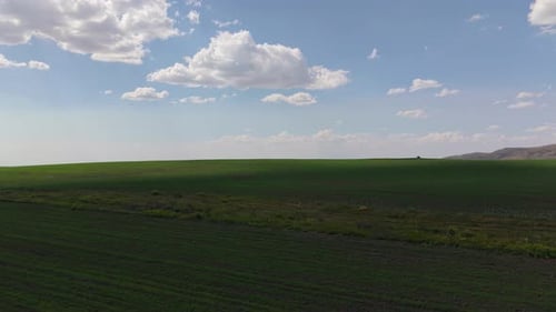 Clouds Passing Over Green Field Creating Moving Shadows