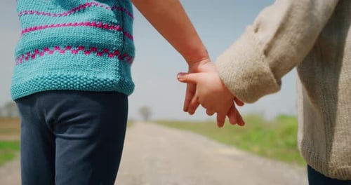 Authentic shot of two cute little girls sisters walking hand in hand on a countryside background i