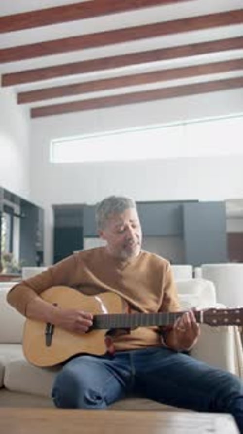 Mature Adult Plays Acoustic Guitar at Home