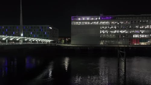 Urban footbridge structure, water reflections, business building, aerial