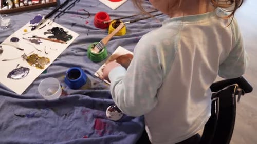 Child Painting Art with Watercolors at Table Indoors