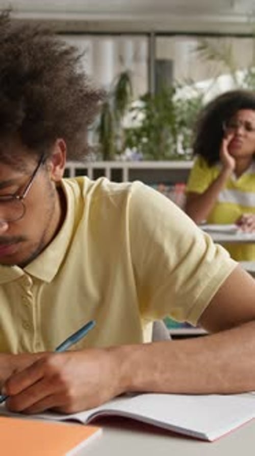 African American Student Guy Writing Test Lesson Suffering with Bullying By Rude Students Throwing
