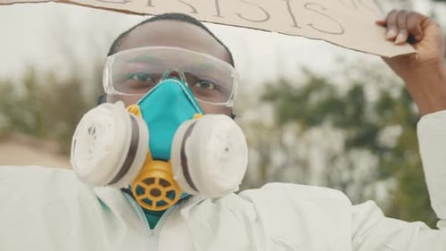 Retrato: Un vigoroso activista negro desempleado con el respirador lleno, un material peligroso blanco en general, en huelga