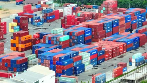 Containerhof von oben: Ein geschäftiges Labyrinth aus gestapelten Containern.