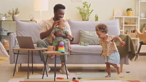 Dad Working From Home With Baby and Child